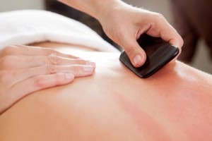 gua sha techniques being used on a person's back