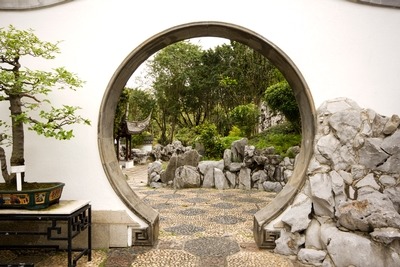 Zen garden with a circular arch looking through to another part of the garden